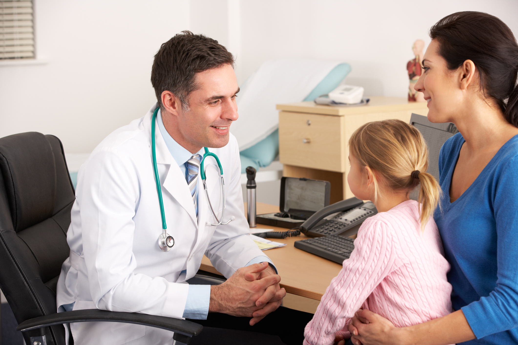 Doctor with child patient and mother