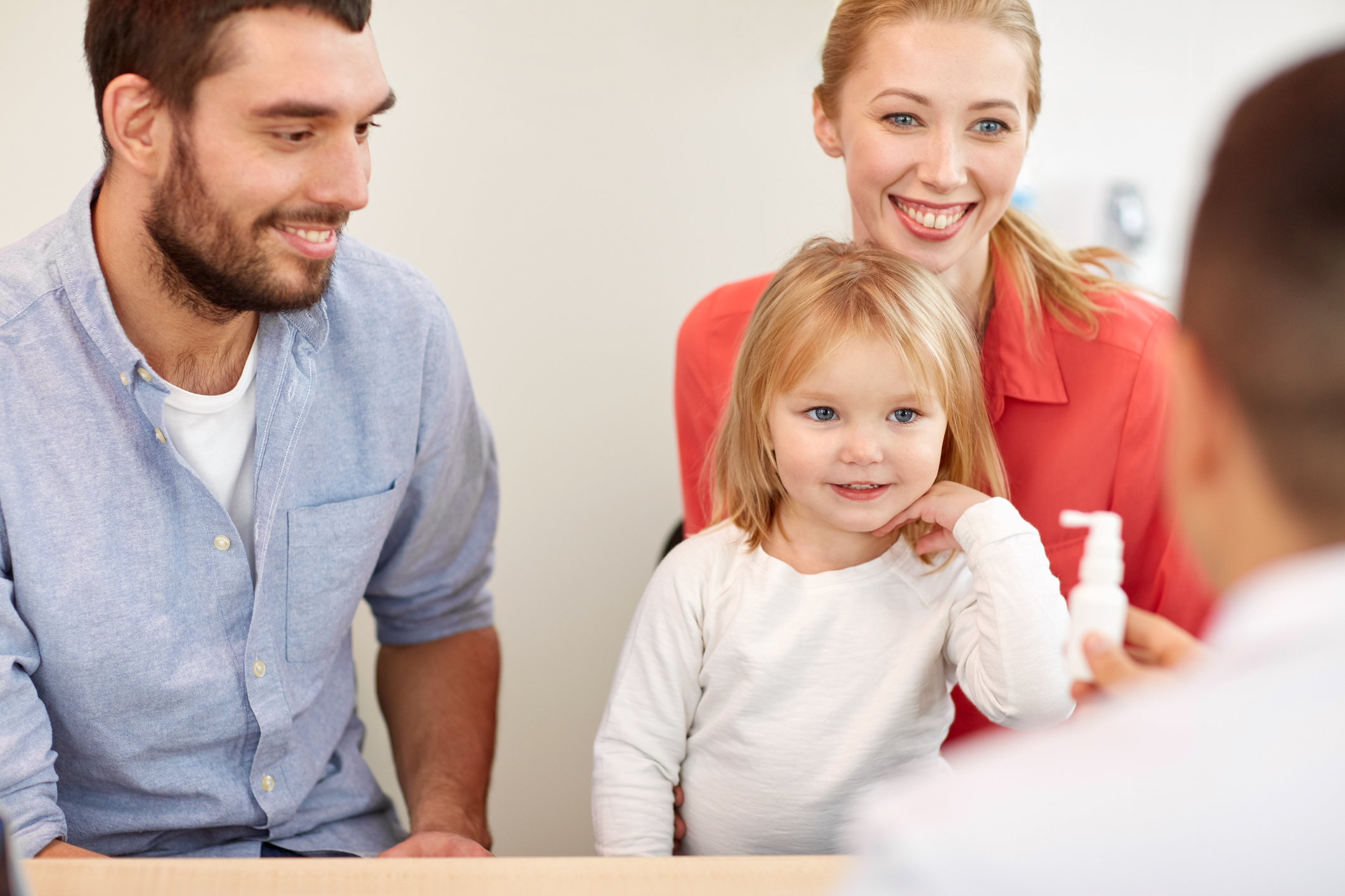 Father, mother and daughter talking to a doctor